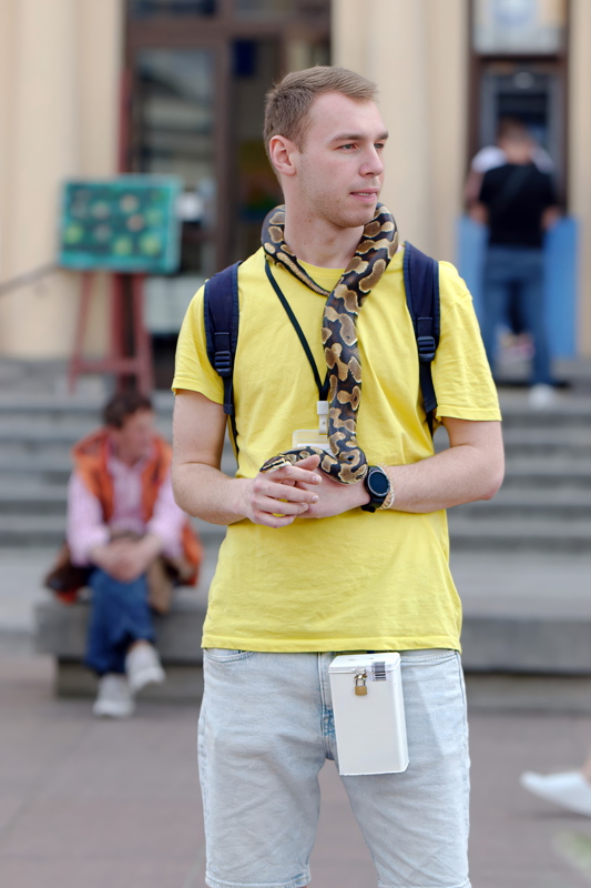 30 - Young man holding a pet royal python around his neck